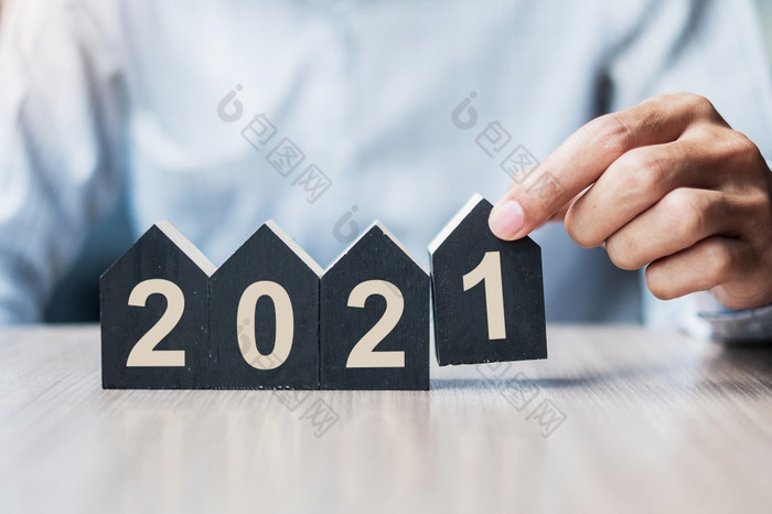 年轻的商人手持有快乐新一年与房子模型表格办公室新房子金融财产保险真正的房地产储蓄和新一年决议概念