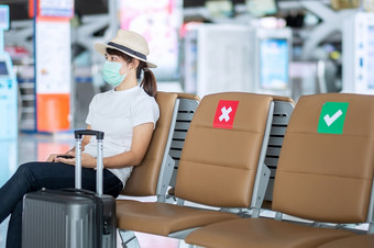 年轻的女穿脸面具和<strong>坐</strong>着椅子机场保护冠状病毒疾病新冠病毒感染亚洲女人<strong>旅行</strong>者新正常的<strong>旅行</strong>泡沫和社会距离