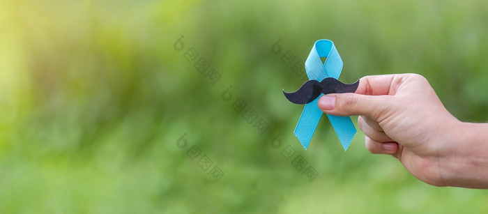 11月前列腺癌癌症意识月成人男人。持有蓝色的丝带与胡子为支持人生活和疾病医疗保健国际但父亲和世界癌症一天概念