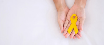 <strong>自杀预防</strong>和童年癌症意识黄色的丝带为支持人生活和疾病孩子们医疗保健和世界癌症一天概念