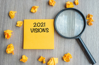 愿景单词黄色的请注意与崩溃了纸和放大玻璃木表格背景新一年新开始的想法策略和目标概念