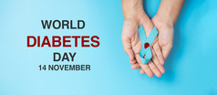 11月世界糖尿病一天意识月女人持有光蓝色的丝带与血下降为支持人生活预防和疾病医疗保健前列腺癌癌症一天概念