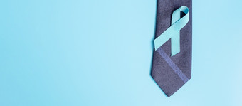 11月前列腺癌癌症意识月光蓝色的丝带与领带蓝色的背景为<strong>支持人</strong>生活和疾病但医疗保健国际但和世界癌症一天概念