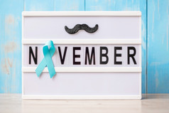 前列腺癌癌症意识月光蓝色的丝带与胡子lightbox与11月文本背景为支持人生活和疾病国际但一天和世界癌症一天概念