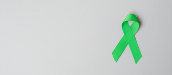 绿色丝带颜色灰色背景为支持人生活和疾病肝胆囊甚至管癌症和器官捐赠意识月概念