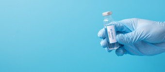 新冠病毒疫苗瓶对冠状病毒感染手医生与腈手套医院实验室医疗健康疫苗接种和免疫接种概念