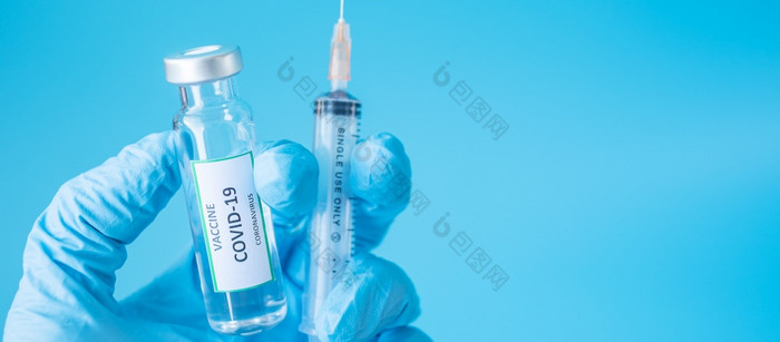 新冠病毒疫苗瓶和注射针注射器对冠状病毒感染手医生与腈手套医院实验室医疗健康疫苗接种和免疫接种概念