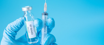 新冠病毒疫苗瓶和注射针注射器对冠状病毒感染手医生与腈手套医院实验室医疗健康疫苗接种和免疫接种概念