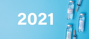 快乐新一年与新冠病毒疫苗瓶和注射针注射器对冠状病毒感染医院实验室医疗健康疫苗接种和免疫接种概念