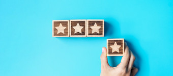 手持有明星块蓝色的背景客户选择评级为用户评论服务评级排名客户审查满意度评价和反馈概念