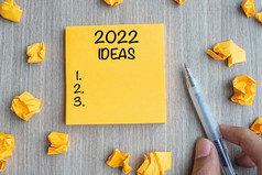 的想法词黄色的请注意与商人持有笔和崩溃了纸木表格背景新一年新开始决议策略任务概念