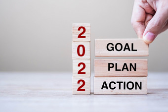 商人手持有木多维数据集与文本目标计划和行动表格背景决议策略解决方案目标业务和新一年假期概念