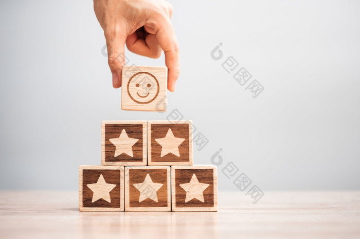 手持有微笑脸在明星象征块表格背景服务评级排名客户审查满意度评价和反馈概念