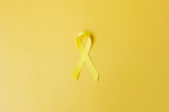 <strong>黄</strong>色的<strong>丝带黄</strong>色的背景为支持人生活和疾病9月自杀预防一天童年癌症意识月和世界癌症一天概念