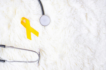黄色的丝带和<strong>听诊器</strong>白色背景为支持人<strong>生活</strong>和疾病9月自杀预防一天童年癌症意识月和世界癌症一天概念
