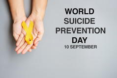 世界自杀预防一天手持有黄色的丝带为支持人生活和疾病