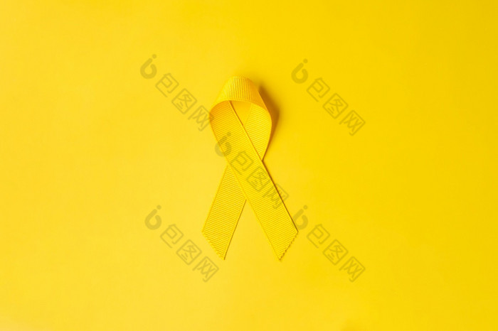 黄色的丝带黄色的背景为支持人生活和疾病9月自杀预防一天童年癌症意识月和世界癌症一天概念