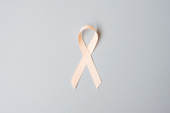 9月子宫癌症意识月桃子丝带为支持人生活和疾病医疗保健和世界癌症一天概念