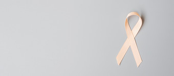 9月子宫癌症意识月桃子丝带为支持人生活和疾病医疗保健和世界癌症一天概念