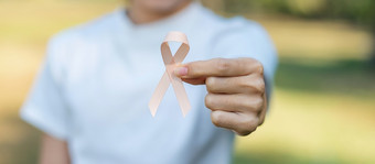 9<strong>月子</strong>宫癌症意识月女人手持有桃子丝带为支持人生活和疾病医疗保健和世界癌症一天概念