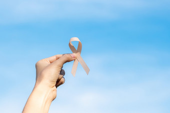 9月子宫癌症意识月女人手持有桃子丝带为支持人生活和疾病医疗保健和世界癌症一天概念