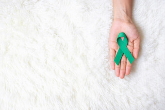9月卵巢<strong>癌症</strong>意识月女人持有蒂尔丝带颜色为支持人生活和疾病医疗保健和<strong>世界癌症</strong>一天概念