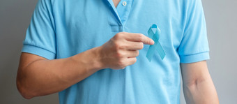 11月前列腺癌<strong>癌症</strong>意识月男人。蓝色的衬衫与手持有蓝色的丝带为支持人生活和疾病医疗保健<strong>国际</strong>但父亲和世界<strong>癌症</strong>一天概念