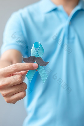 11月前列腺癌癌症意识月男人。持有蓝色的丝带与胡子为支持人生活和疾病医疗保健国际但父亲和世界癌症一天概念