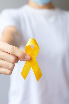 自杀预防一天肉瘤骨膀胱和童年癌症意识月黄色的丝带为支持人生活和疾病孩子们医疗保健和世界癌症一天概念