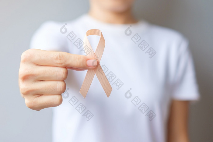 女人手持有桃子丝带为9月子宫癌症意识月医疗保健和世界癌症一天概念