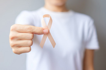 女人手持有桃子丝带为9<strong>月子</strong>宫癌症意识月医疗保健和世界癌症一天概念