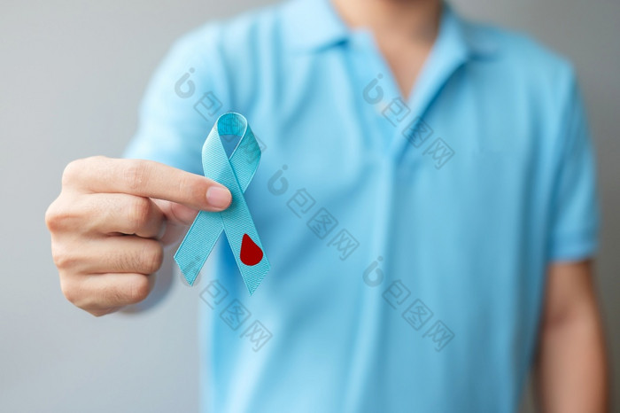 11月世界糖尿病一天意识月男人。持有光蓝色的丝带与血下降形状为支持人生活预防和疾病医疗保健前列腺癌癌症一天概念