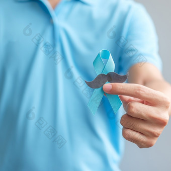 11月前列腺癌癌症意识月男人。持有蓝色的丝带与胡子为支持人生活和疾病医疗保健国际但父亲和世界癌症一天概念