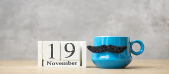 国际但一天与11月日历蓝色的咖啡杯茶杯子和黑色的胡子装饰表格快乐父亲一天和庆祝活动概念