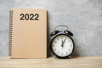 快乐新一年与空白笔记本黑色的复古的报警时钟和木数量倒计时决议目标计划行动和任务概念