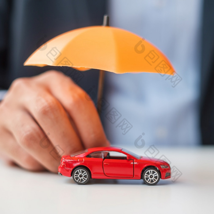 商人手持有伞和封面红色的车玩具表格车保险保修修复金融银行和钱概念