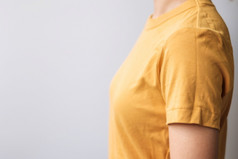 女人穿黄色的颜色衬衫灰色的背景与复制空间为文本