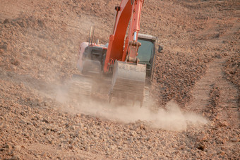 橙色挖掘机下建设大储层灰尘挖掘的土壤