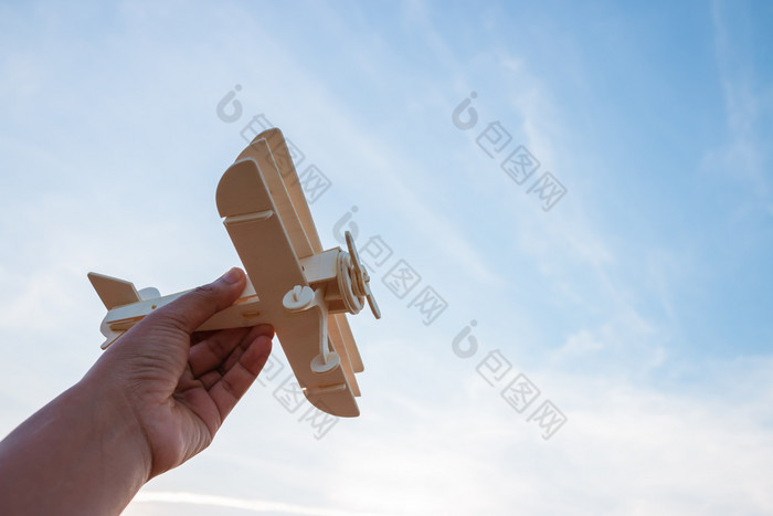 自由概念人类手持有木飞机的日落天空背景