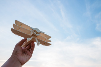 自由概念人类手持有木飞机的日落天空背景