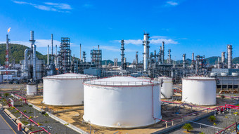 石油炼油厂和石化植物工业工作与火和蓝色的天空背景空中视图石油和气体炼油厂一天