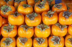 成熟的橙色柿子水果市场摊位