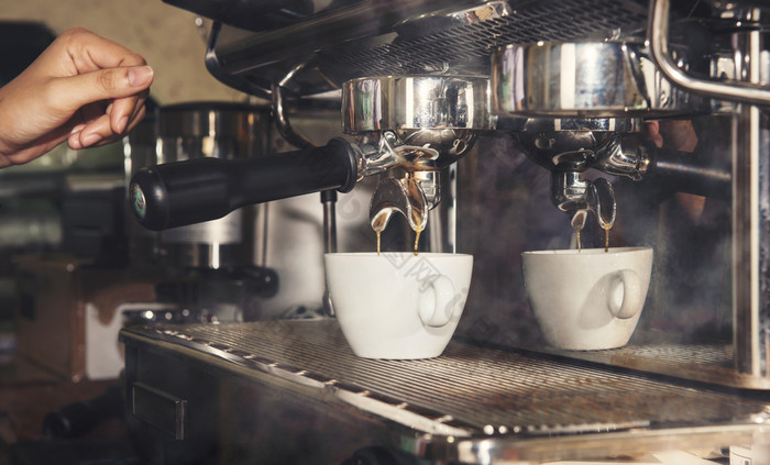 手咖啡师使咖啡白色杯与咖啡机的咖啡商店人与咖啡师咖啡馆概念