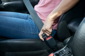 女人手紧固<strong>安全带</strong>的车裁剪图像女人坐着车和把她的座位带安全开车概念