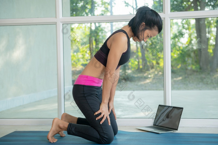 女人练习瑜伽做向上腹部锁锻炼乌迪亚纳班达构成工作出穿运动服装看健身视频教程在线移动PC做锻炼首页坐着