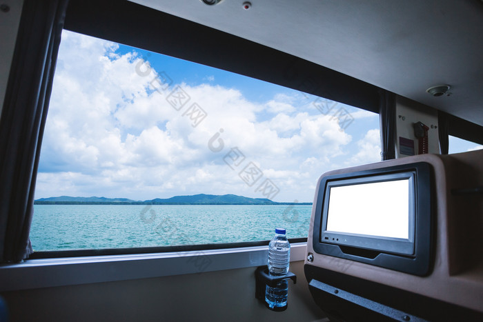 内部的公共汽车哪一个有液晶显示器屏幕空白后座位为娱乐与瓶水和窗口视图美丽的景观自然的海与天空云数字旅游路旅行概念