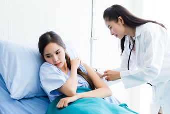亚洲年轻的女医生与注射器的手臂亚洲年轻的女病人床上为更好的疗愈的房间<strong>医院背景</strong>