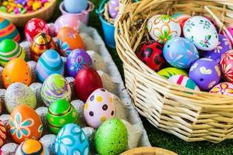 复活节假期概念色彩斑斓的复活节鸡蛋蛋盒子篮子复活节鸡蛋糖果篮子兔子娃娃绿色草背景与空间