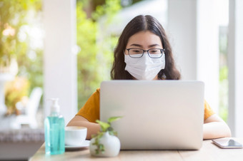 自由人业务女穿保护面具休闲工作与移动PC电脑咖啡商店就像的背景工作从首页概念预防的传播新冠病毒病毒
