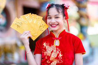 肖像<strong>美丽</strong>的微笑可爱的小亚洲女孩穿红色的传统的<strong>中国</strong>人旗袍装饰持有黄色的信封手为<strong>中国</strong>人新一年节日<strong>中国</strong>人神社